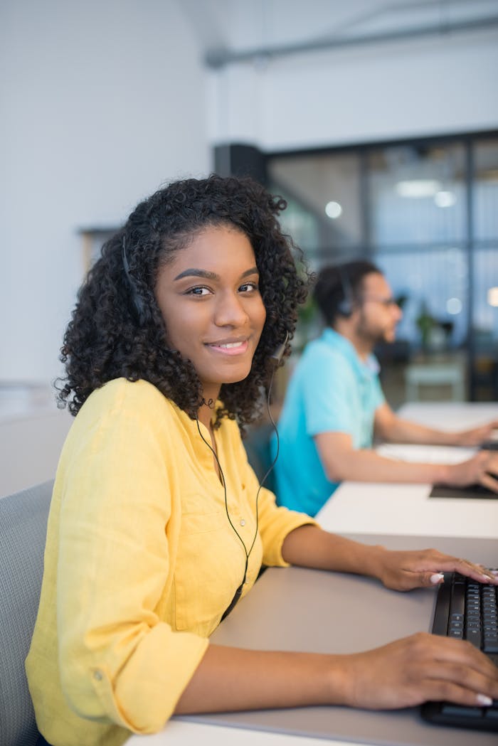 creative Young woman in a bright office, wearing headphones and working on a computer.